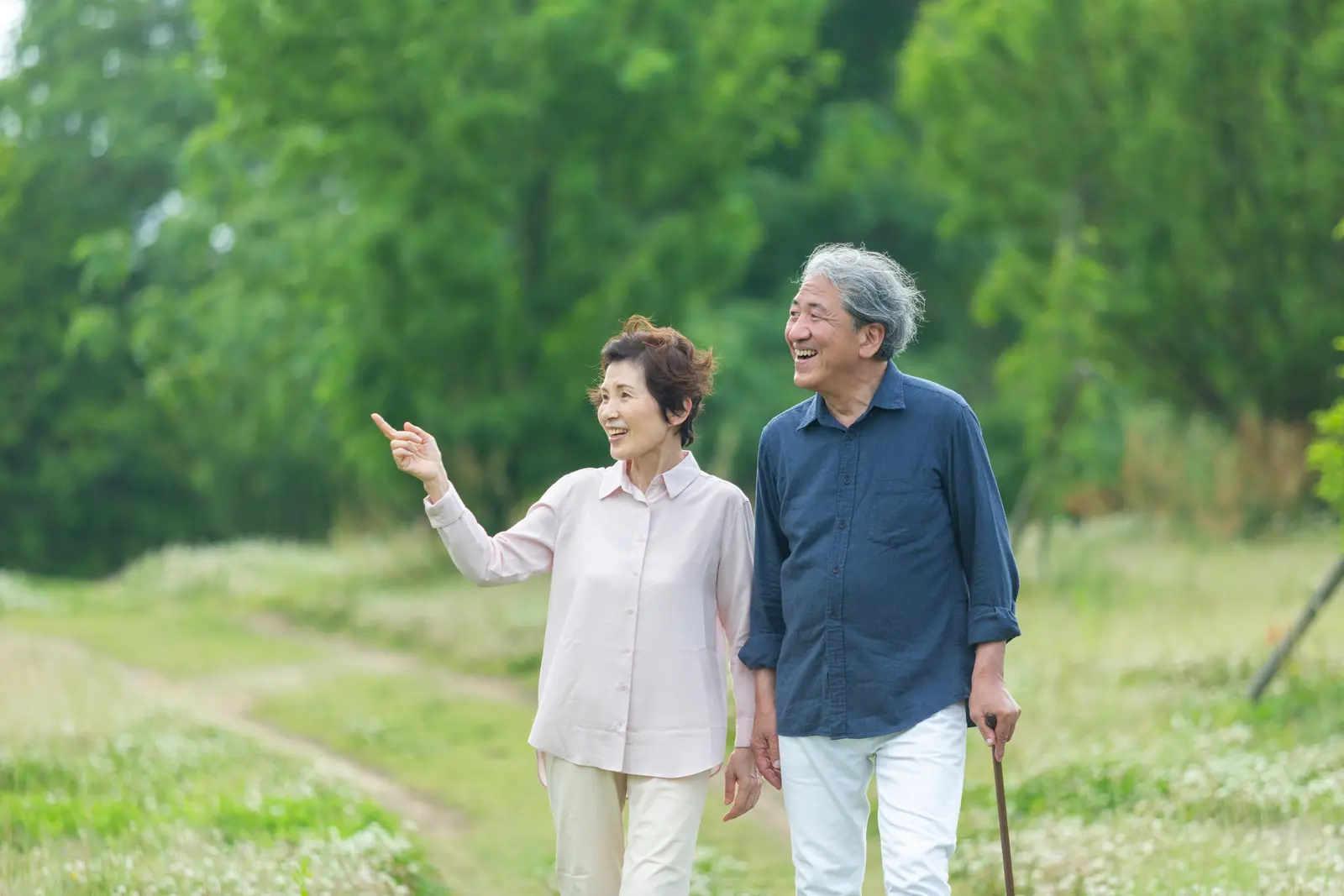 公園を並んで歩く年配の夫婦