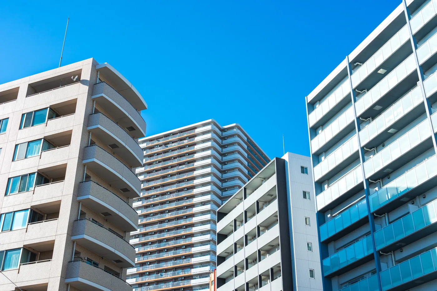 幾何学的な外観の高層マンションと青空