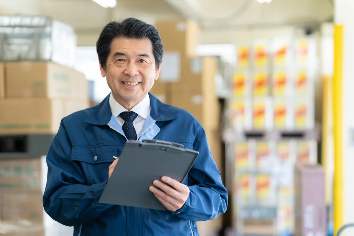 ネクタイ姿で笑顔を見せるベテラン社員